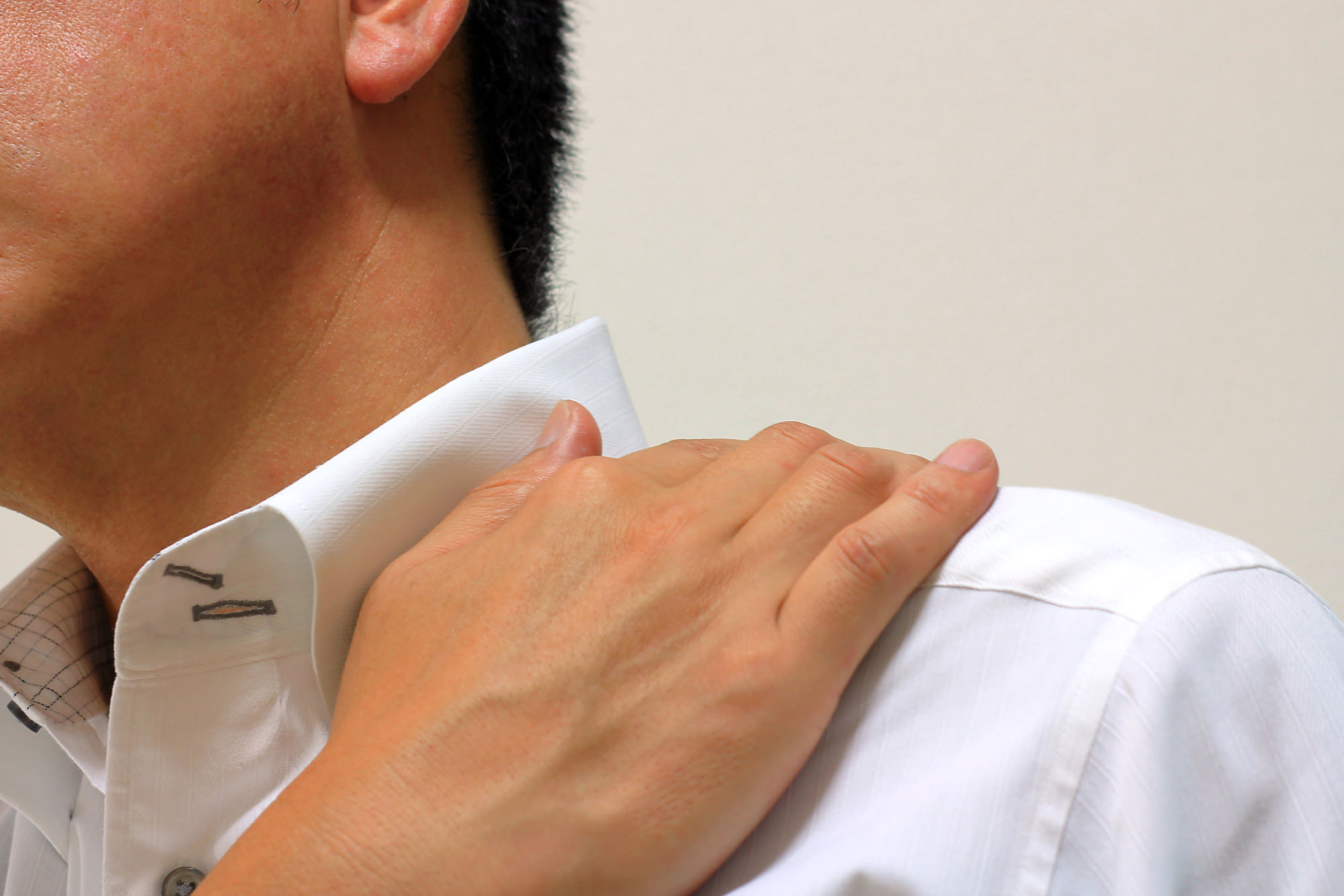 肩をおさえる男性